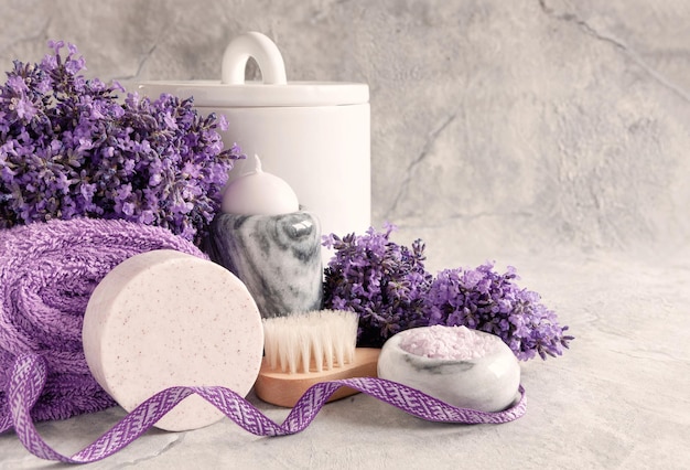 Bougie de fleurs de lavande dans le chandelier en marbre sel de bain aromatique autres fournitures d'hygiène et serviettes sur fond de marbre