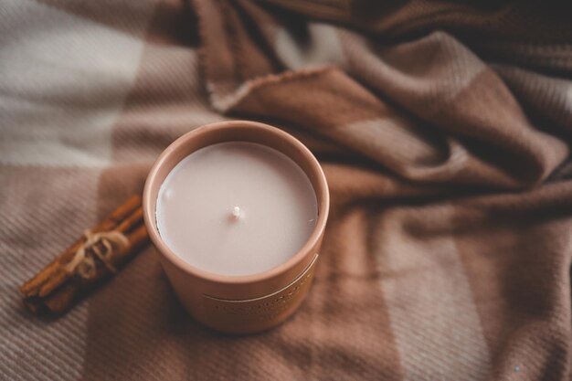 Une bougie avec un parfum de cannelle, un automne confortable.