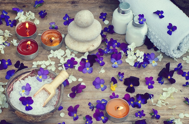 Bougies allumées et set de spa avec sel de bain, pierres pour massage chaud