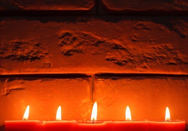 Les bougies allumées sont sur la vieille surface en pierre.