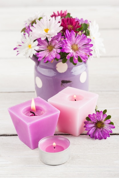 Bougies allumées violettes et fleurs de jardin roses