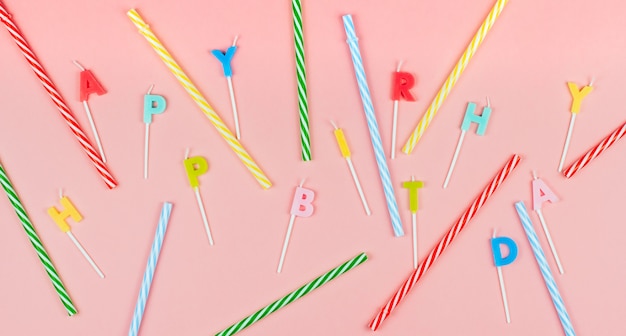 Bougies d'anniversaire multicolores et pailles à rayures pour un cocktail