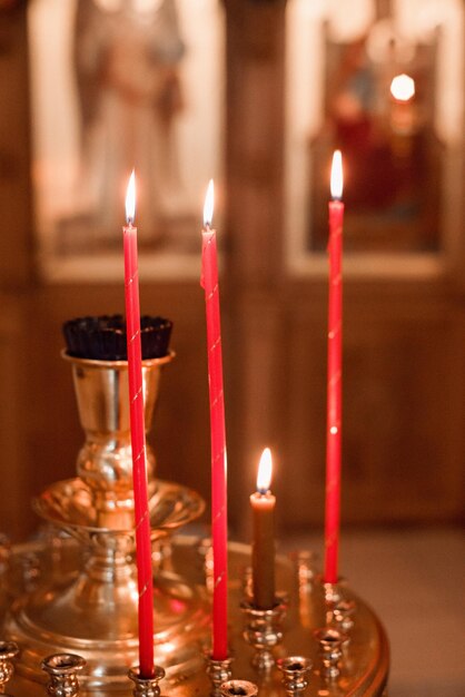 Des bougies brûlent dans un candélabre d'église Attributs de l'église