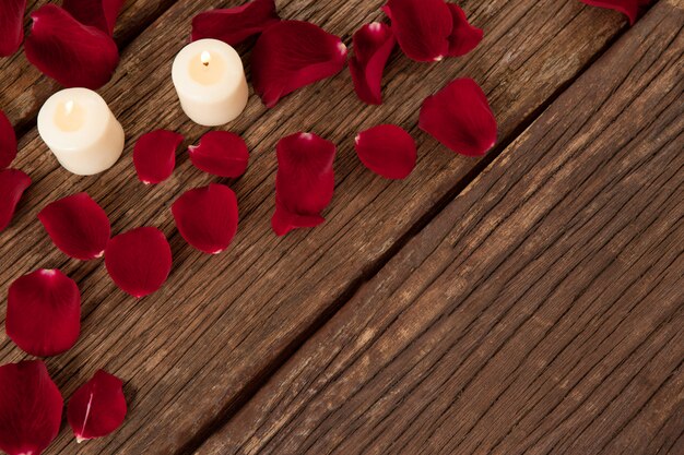 Bougies en cire entourées de pétales de rose