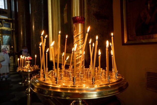 Bougies dans l'église chrétienne orthodoxe Une collection de bougies de prière allumées sur fond sombre