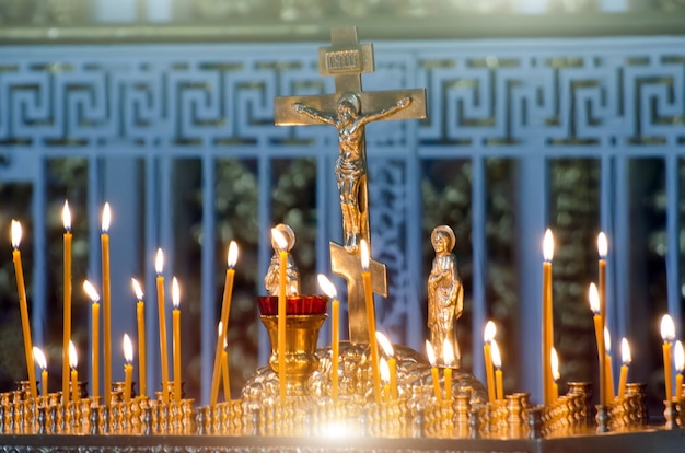 Bougies dans l'obscurité contre la croix orthodoxe.