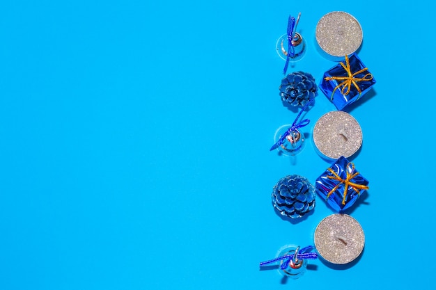 Bougies et décorations de Noël sur fond bleu, fond festif de Noël, mise en page à plat, vue de dessus.