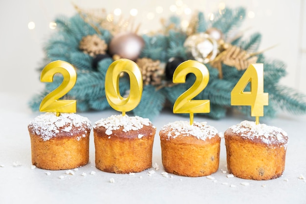 Photo des bougies dorées avec le numéro 2024 sur le dessus du cupcake joyeux noël et bonne année