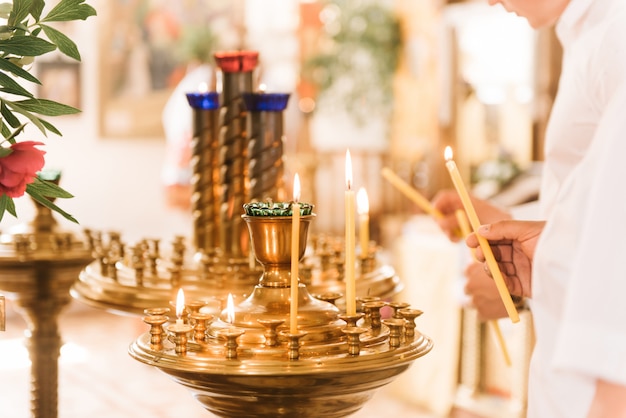 Photo bougies d'éclairage à la main dans une église.