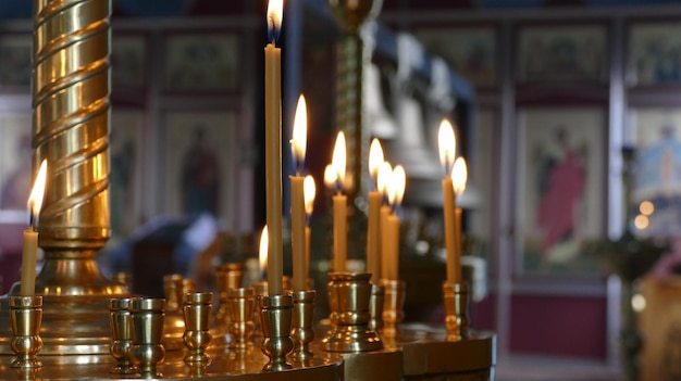 Des bougies d'église devant des icônes à l'intérieur d'un temple