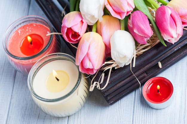 Photo bougies parfumées jaunes et roses avec des tulipes