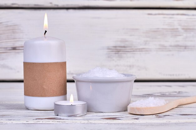 Bougies et sel blanc pour un soin spa sur un bureau en bois