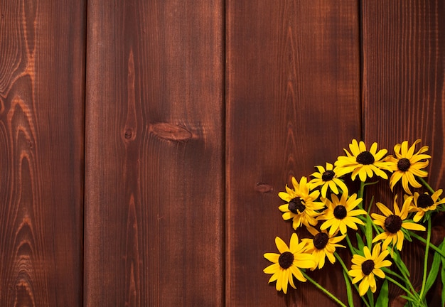 Photo bouguet de fleurs jaunes en coin sur fond de bois