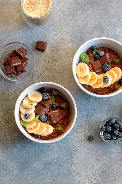 Bouillie d'avoine au chocolat avec myrtille, feuilles de menthe et banane dans un bol. petit-déjeuner