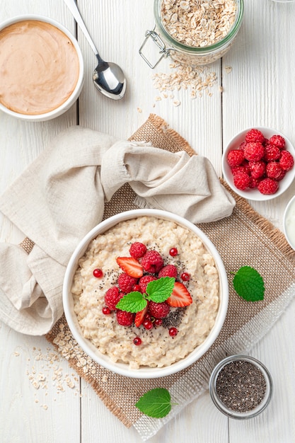 Bouillie d'avoine avec fraises framboises fraîches et groseilles rouges sur fond blanc