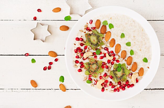 Photo bouillie d'avoine savoureuse et saine avec kiwi, grenade et graines. petit-déjeuner sain.