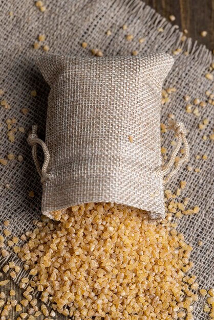 Photo bouillie de blé frais dans un sac en lin, gros plan de gruau de blé frais dans un sac