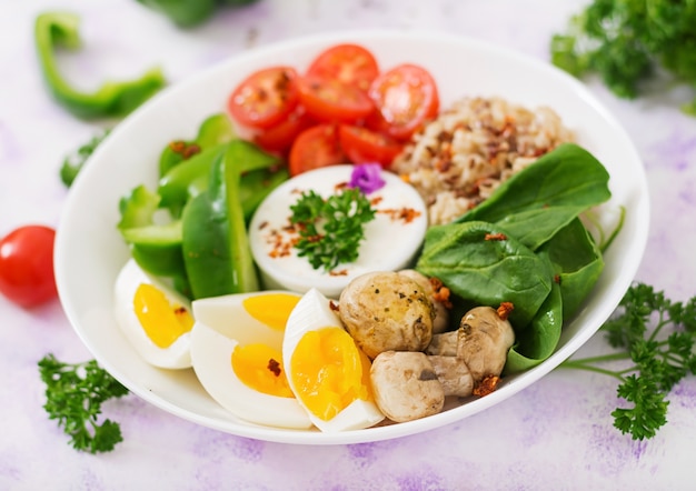 Photo bouillie de flocons d'avoine, oeuf et légumes frais - tomates, épinards, paprika, champignons