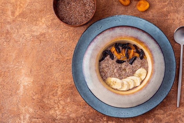 Bouillie de lin végétalien à base de graines fraîches avec des amandes et des abricots secs sur un fond clair. Source Oméga 3.