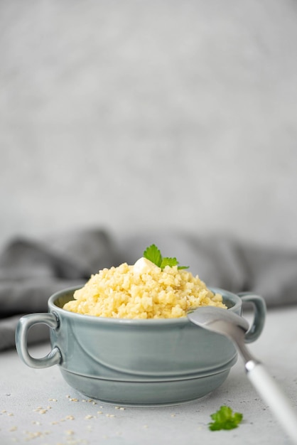 Bouillie de millet bouillie avec de l'huile de sésame et du persil dans un gros plan de plaque grise