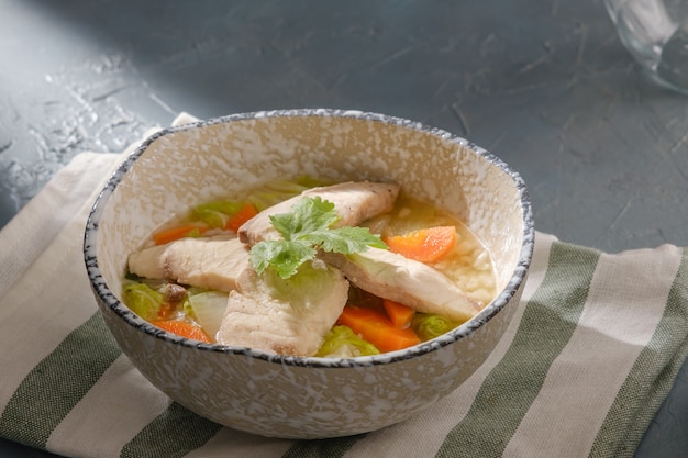 Bouillie de poisson Snakehead garnie de coriandre dans un bol sur table grise. soupe de riz avec tranches de poisson. Congee ou conjee est un type de bouillie de riz ou de gruau populaire dans de nombreux pays asiatiques.