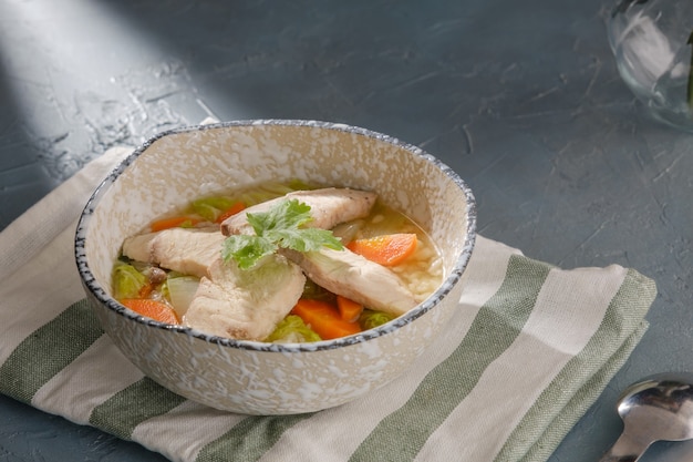 Bouillie de poisson en tranches de tête de serpent garnie de coriandre dans un bol sur table grise soupe de riz avec des tranches de poisson