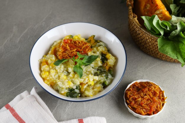 Bouillie de riz traditionnelle Bubur Manado mélangée à des légumes de maïs à la citrouille