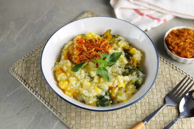 Bouillie de riz traditionnelle Bubur Manado mélangée à des légumes de maïs à la citrouille