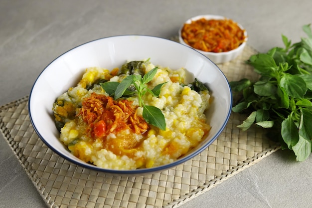 Bouillie de riz traditionnelle Bubur Manado mélangée à des légumes de maïs à la citrouille