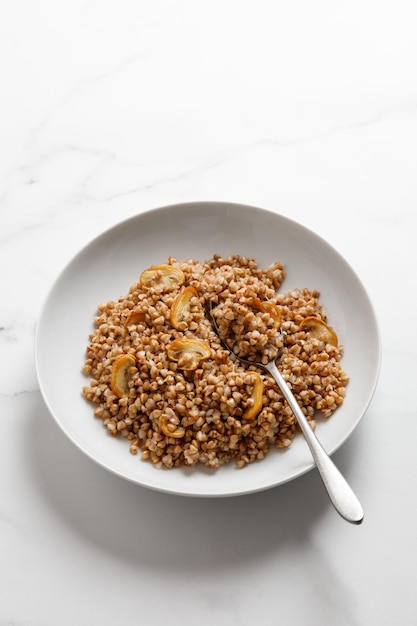 Bouillie de sarrasin bouillie aux champignons avec une cuillère sur une table en marbre