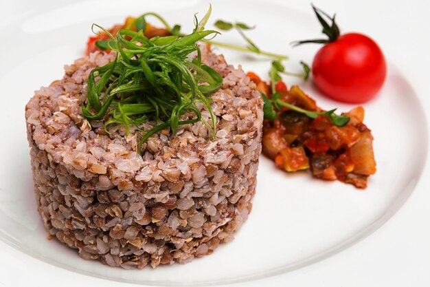 Bouillie de sarrasin avec une salade de légumes cuits au four sur une assiette