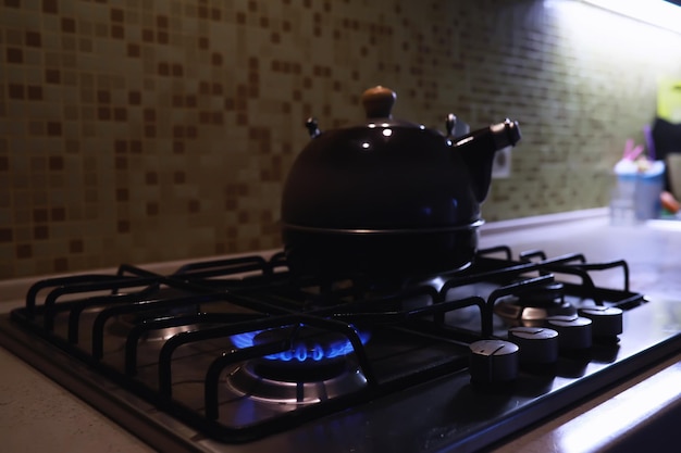 Photo bouilloire avec un sifflet sur la cuisinière à gaz panneau de gaz intégré la bouilloire est sur la cuisinière crise du gaz