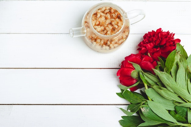 Bouilloire en verre de tisane avec des fleurs fraîches se bouchent