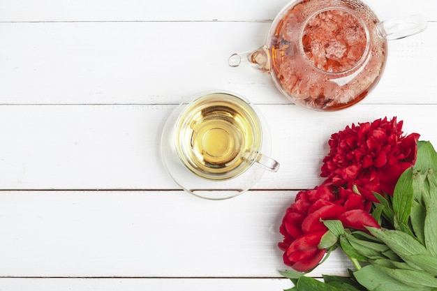 Bouilloire en verre de tisane avec des fleurs fraîches se bouchent