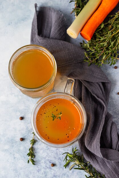 Bouillon d'os maison dans une tasse en verre et légumes