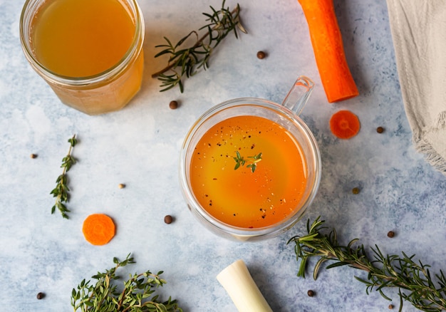 Bouillon d'os maison dans une tasse en verre et légumes