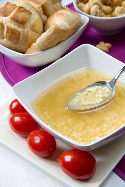 Photo bouillon et petites pâtes avec une cuillère