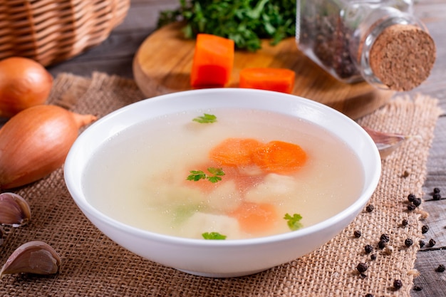 Bouillon de poisson frais. Soupe de poisson avec des ingrédients et des épices pour la cuisine. Fond en bois