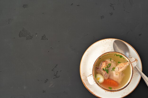 Bouillon de poulet avec moitié de poulet dans un bol blanc