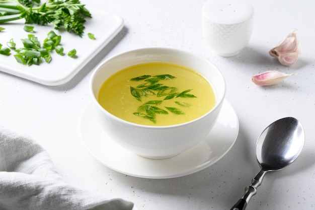 Bouillon de poulet à l'oignon vert dans un bol blanc sur un tableau blanc Copier l'espace