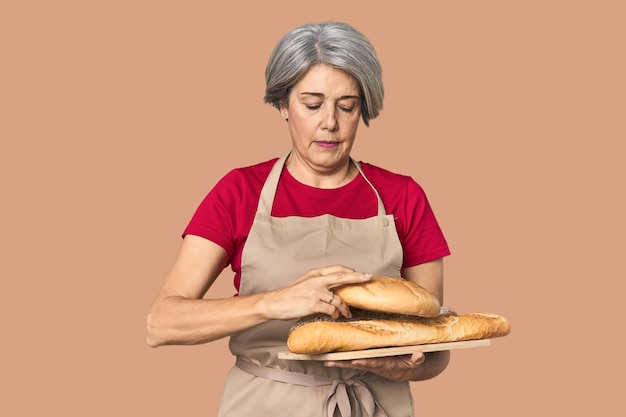 Boulanger blanche d'âge moyen avec un plateau de pain