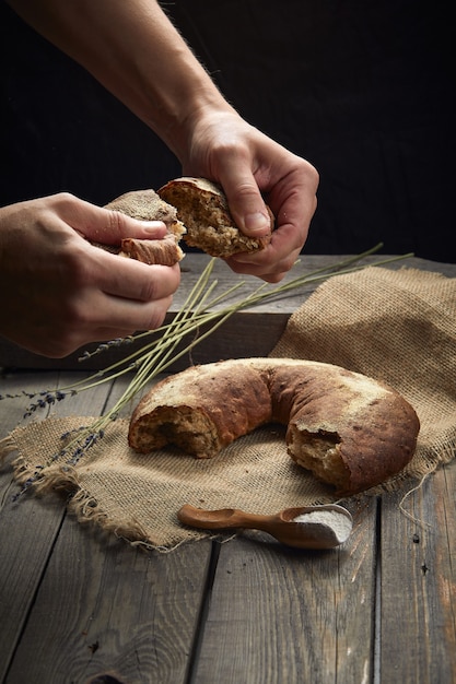 Le boulanger casse le pain sur la table