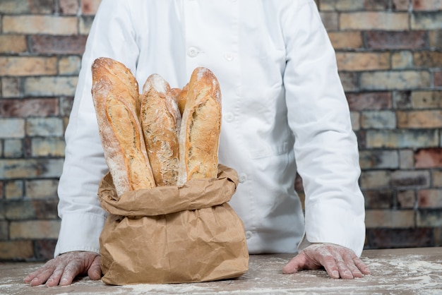 Boulanger avec du pain traditionnel français baguettes