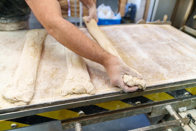 Un boulanger habile fabrique des baguettes crues prêtes pour le four