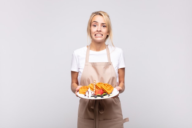 Boulanger de jeune femme jolie blonde. concept de gaufre