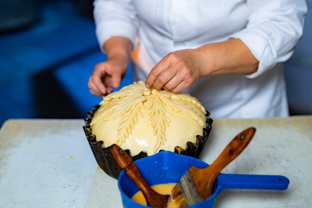 Boulanger professionnel préparant du pain sucré. Décoration de pâtisserie sur ligne de production.