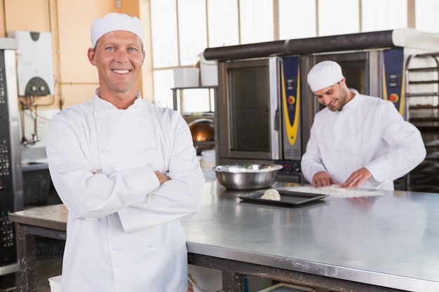 Boulanger souriant debout avec les bras croisés