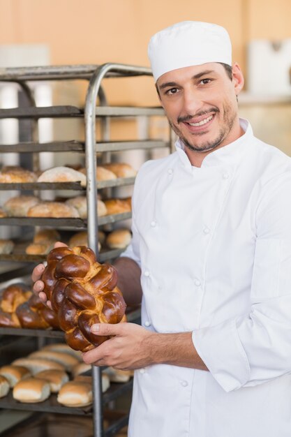 Boulanger souriant tenant des pains frais