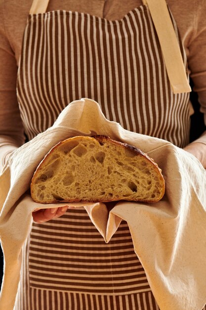 Boulanger tenant une miche de pain fait maison