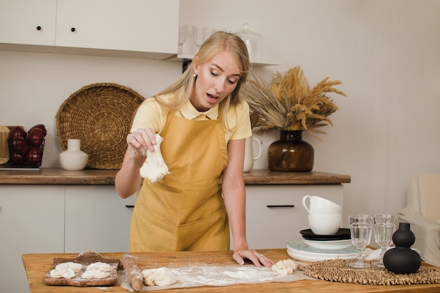 Une boulangère ou une femme au foyer regarde la pâte et réfléchit à ce qu'elle doit cuisiner.